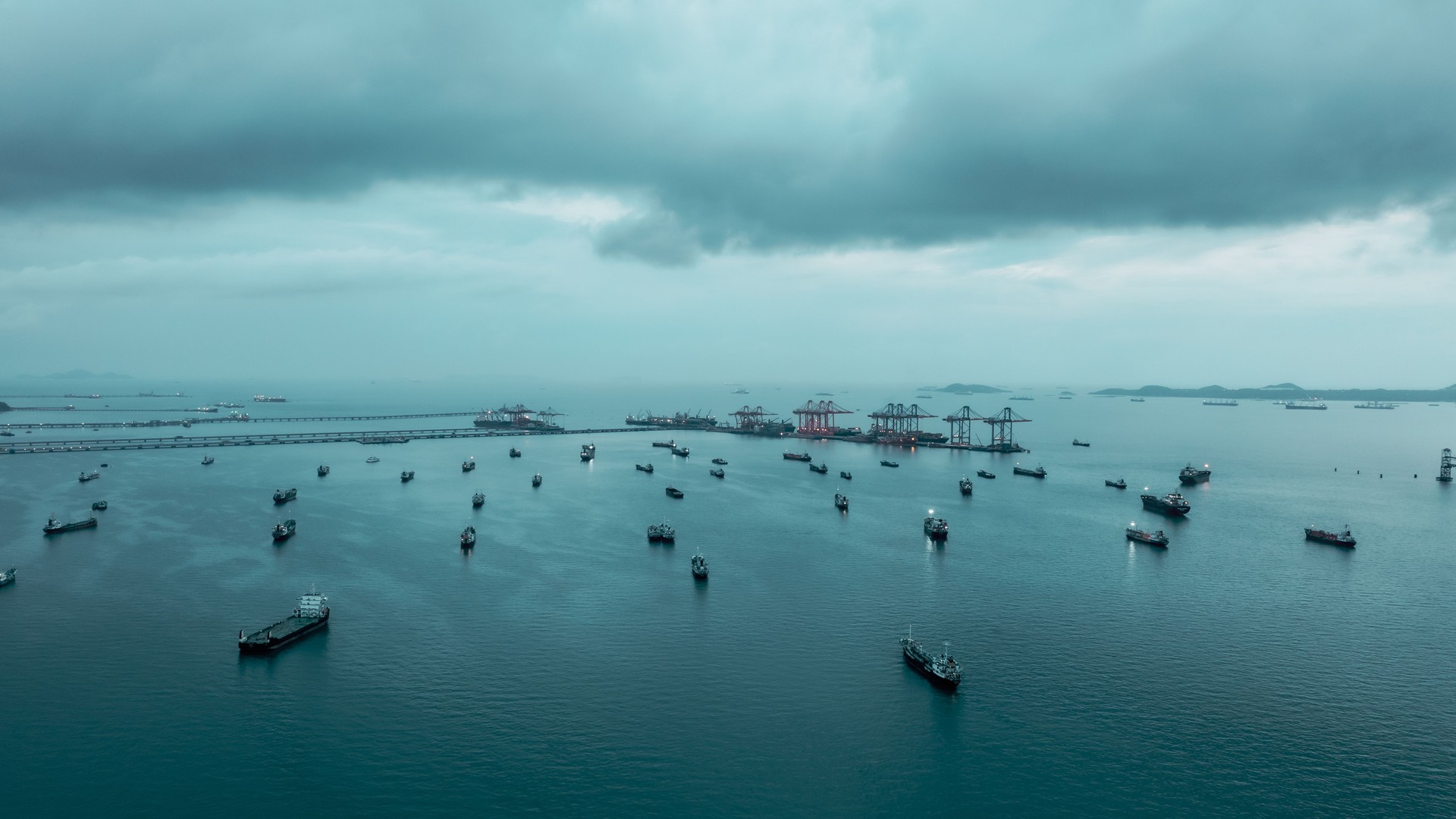 Aerial view Oil ship tanker parking in sea and cloud storm background, waiting for load and unload oil from refinery for transportation.